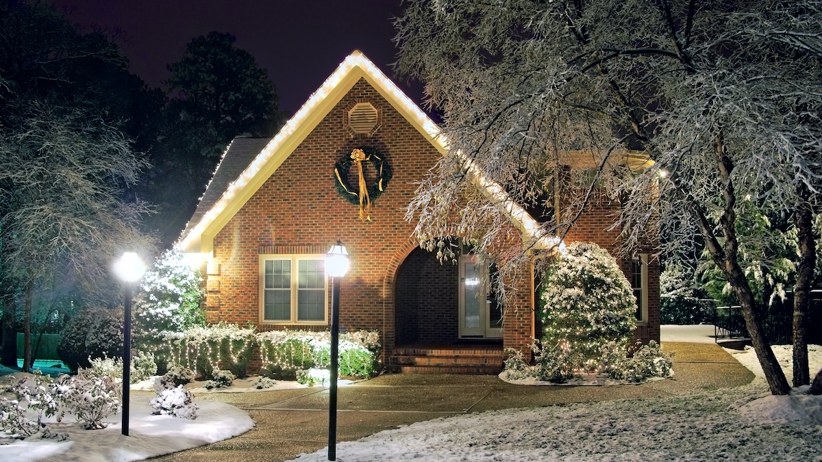 Christmas decorated brick cottage dusted in snow - Christmas 2019