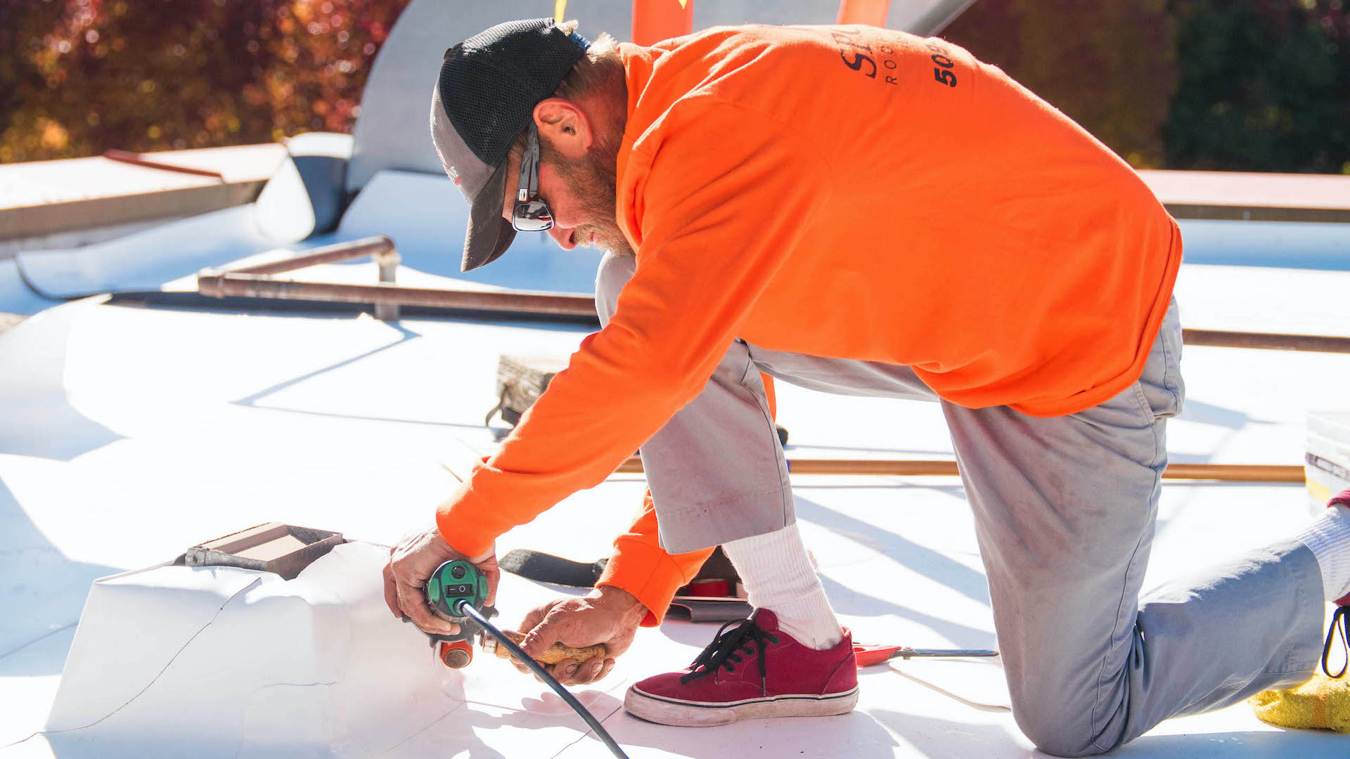 Roofer Installs TPO Roofing Around A Pipe Support Using A Hand-Held, Hot Air Welder