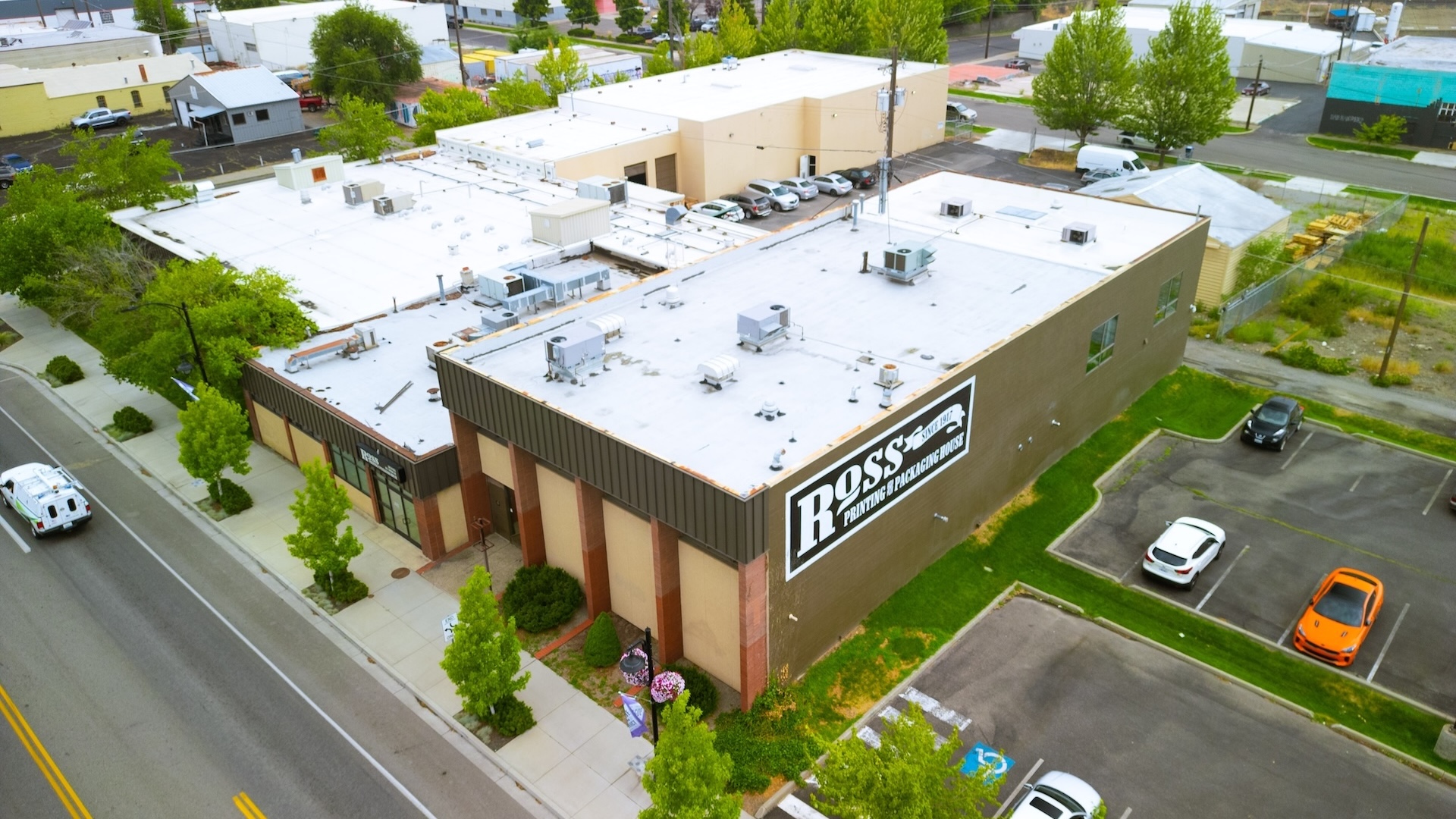 Ross Printing Buildings With Commercial Flat Roofs Of Varying Sizes, Ages, And Materials